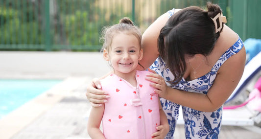 Petite fille souriante en maillot de bain flottant enfant fille avec sa maman