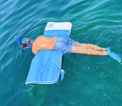 Une personne fait du snorkeling grâce au confort flottant du matelas flottant Plouf