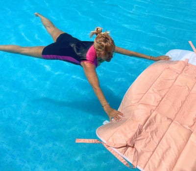 Une femme portant le maillot de bain flottant fait de l’exercice grâce au matelas Safety Concept by Plouf