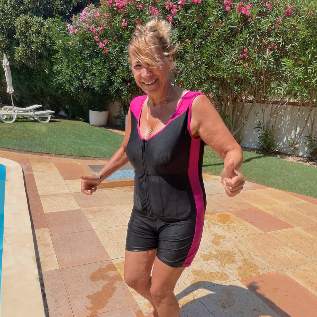 A smiling woman wearing floating swimsuit for women Safety Concept by Plouf, by the pool.